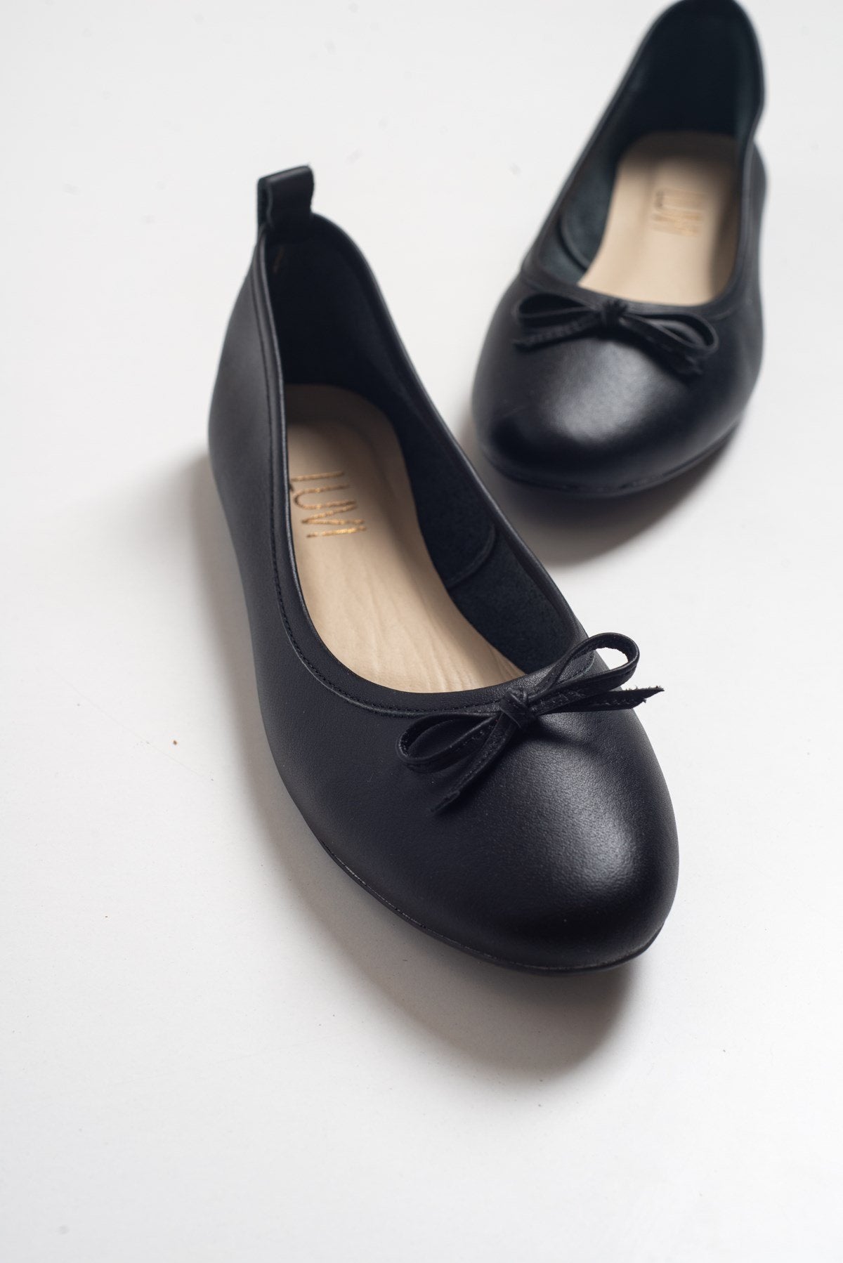 Florence - Black Ballerina Flats – front three-quarter view showing bow, leather, suede, Vowalisse
