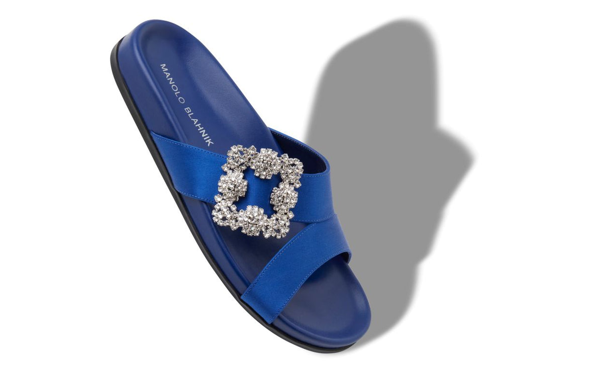 Estelle Grace Blue Jewel Buckle Mules – front three-quarter view showing blue jewel buckle, crossover, open toe, satin…