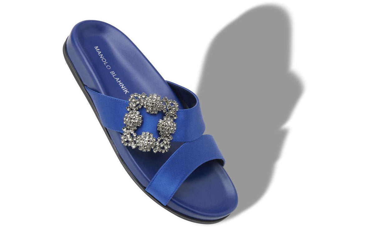 Fiorella Halo Blue Jewel Buckle Mules – front three-quarter view showing blue jewel buckle, crystal buckle, crossover, open…
